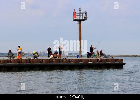 Pescatori sul molo uscendo dalla storica stazione della guardia costiera nel porto di Cleveland Foto Stock