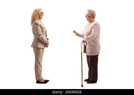 Profilo a lunghezza intera di una donna matura e di una donna anziana che ha una conversazione isolata su sfondo bianco Foto Stock