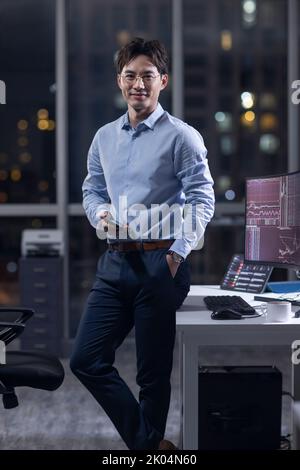 Uomo d'affari cinese che lavora in ufficio di notte Foto Stock