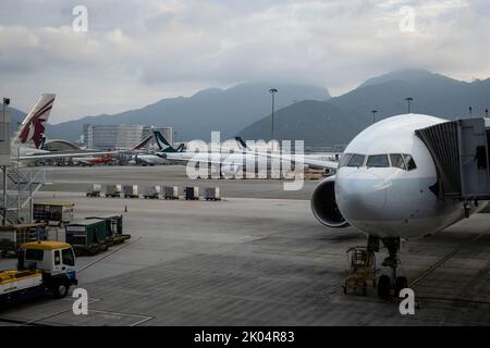 Una vista esterna degli aeromobili parcheggiati nell'Aeroporto Internazionale di Hong Kong. Poiché i paesi di tutto il mondo hanno allentato la politica di quarantena dopo due anni di pandemia, il governo di Hong Kong ha annunciato di allentare la politica di quarantena COVID-19 a partire dal 12 agosto 2022, la quarantena degli hotel per gli arrivi all'estero sarà ridotta da 7 a 3 giorni, Seguiti da quattro giorni di sorveglianza medica a casa o in un alloggio alternativo, gli arrivi devono essere testati con PCR e test RAT non appena attraversano il confine. Foto Stock