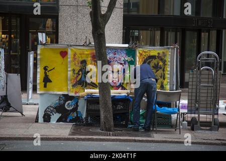 L'uomo vende opere d'arte su tela sulla 53rd Street di fronte al Museum of Modern Art (MoMA) di New York. Foto Stock