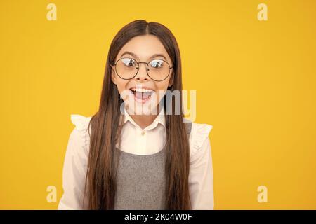 Faccia eccitata. Bambina adolescente con espressione facciale scioccata. Espressione del volto sorpresa, isolata su sfondo giallo. Buona sorpresa. Stupito Foto Stock