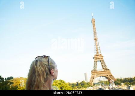È magnifico. Vista posteriore di una giovane donna che guarda alla Torre Eiffel. Foto Stock