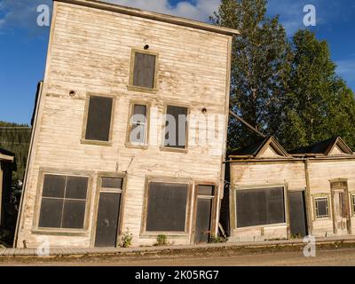 Vecchi edifici in legno crollano mentre il terreno perma-frost affonda sotto un effetto a lungo termine di cambiamento delle condizioni climatiche. Foto Stock