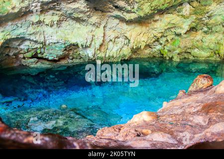 Vista della splendida piscina naturale di acqua cristallina formata in una grotta rocciosa con stalagmiti e stalagmiti. Caverna di Kuza a Zanzibar, Tanzania Foto Stock