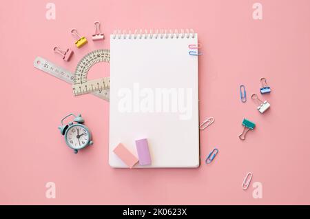 La scuola fornisce accessori su sfondo rosa, piatto, vista dall'alto. Beffa Foto Stock