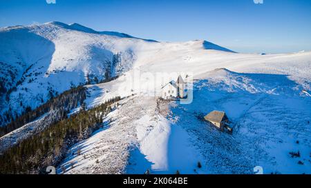 Vista aerea della cappella di Maria Schnee in Austria in una splendida giornata invernale Foto Stock