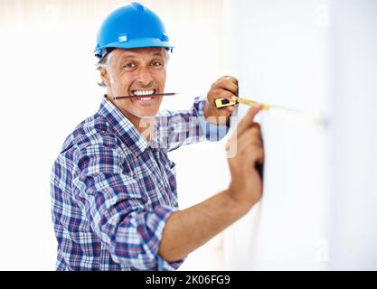 Ingegnere impegnato. Ritratto di ingegnere maturo al lavoro tenendo la matita in bocca. Foto Stock