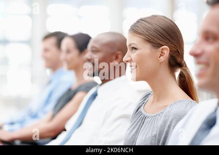 Riunioni utili - uomini d'affari. I partner commerciali siedono in un seminario che si concentra tranquillamente - concentrarsi sulla donna. Foto Stock