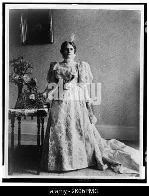 McKinley, ritratto completo, in piedi, davanti, tra 1890 (?) e 1900(?). [Moglie del presidente William McKinley - immagine del presidente McKinley sul tavolo accanto a lei]. Foto Stock