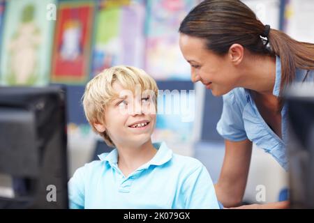 So che i computer sono difficili, ma youre fare grande. Un giovane insegnante attraente che assiste uno scolaro durante la lezione di computer. Foto Stock