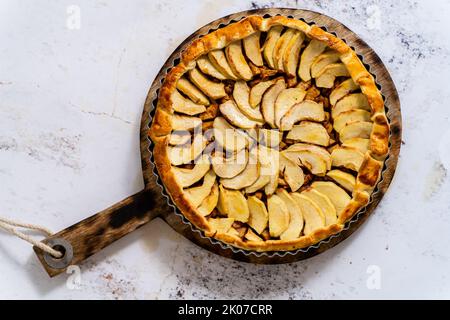 Torta di mele appena sfornata con frutta su un tavolo di pietra Foto Stock