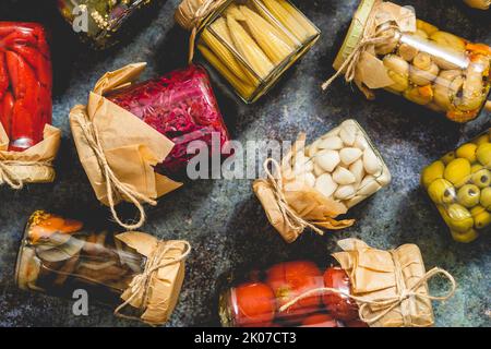 Vasetti di decapaggio chiusi con verdure varie su tavola di pietra Foto Stock