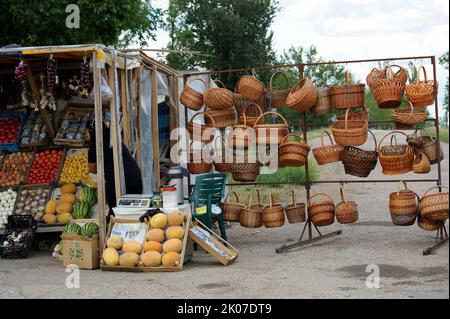 Ragazza giovane venditore di strada che vende verdure ai clienti, cesti di vimini, mercato alimentare a bordo strada. Giugno 10, 2017. Simferopol - Kyiv autostrada vicino a Jankoy, Foto Stock