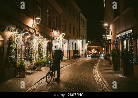 VILNIUS, LITUANIA - 2021 DICEMBRE: Strade strette del centro storico di Vilnius decorate per Natale. Festeggia il Natale e il Capodanno in lituano Foto Stock