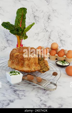 Cucina sveva, torta di bietole con salsa alle erbe, formaggio cagliato, pasticceria sostanziosa, torta salata, vegetariano, cottura, griglia di raffreddamento, griglia per torte, grattugia per noce moscata Foto Stock