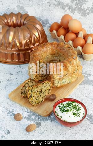 Cucina sveva, gugelhupf di bietole con salsa alle erbe, formaggio casolare, pasticceria sostanziosa su tavola di legno, torta salata, vegetariana, torta, noce moscata di fronte, uova Foto Stock