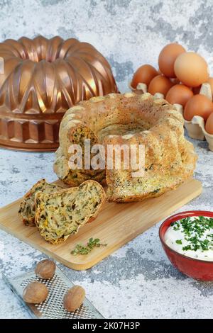 Cucina sveva, dolce svizzero con salsa alle erbe, formaggio riccio, pasticceria sostanziosa su tavola di legno, torta salata, vegetariana, cottura, grattugia alla noce moscata Foto Stock