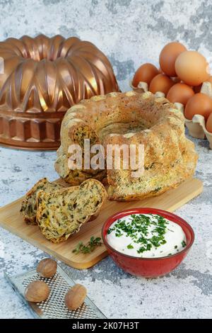 Cucina sveva, dolce svizzero con salsa alle erbe, formaggio riccio, pasticceria sostanziosa su tavola di legno, torta salata, vegetariana, cottura, grattugia alla noce moscata Foto Stock