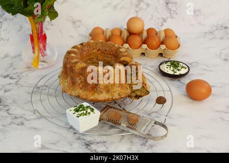 Cucina sveva, torta di bietole con salsa alle erbe, formaggio cagliato, pasticceria sostanziosa, torta salata, vegetariano, cottura, griglia di raffreddamento, griglia per torte, grattugia per noce moscata Foto Stock