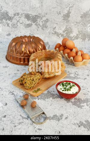 Cucina sveva, dolce svizzero con salsa alle erbe, formaggio riccio, pasticceria sostanziosa su tavola di legno, torta salata, vegetariana, cottura, grattugia alla noce moscata Foto Stock