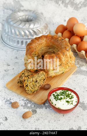 Cucina sveva, gugelhupf di bietole con salsa alle erbe, formaggio casolare, pasticceria sostanziosa su tavola di legno, torta salata, vegetariana, torta, noce moscata di fronte, uova Foto Stock