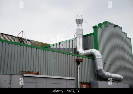 Camino fumi fissata alla costruzione di parete esterna in acciaio inox da scarico impianto caldaia a camera Foto Stock