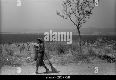 Bulgaria, Nessebar, 23. 08. 1986, donna con pattumiera sulla spiaggia del Mar Nero a Nessebar Foto Stock