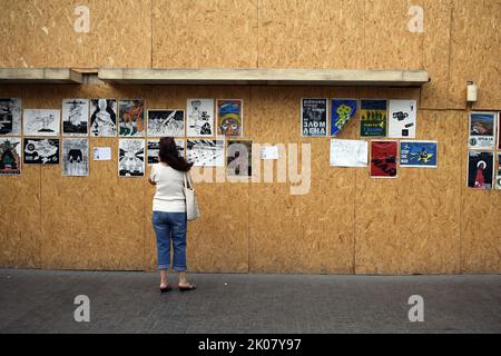 Odessa, Ucraina. 09th Set, 2022. Una donna guarda i manifesti anti-guerra di Ave Libertatemaveamor lungo Deribasovskaya Street, Odesa. Dall'inizio della guerra su vasta scala della Russia contro l'Ucraina, molti negozi al dettaglio sono stati costretti a coprire le finestre con strutture di legno protettive per motivi di sicurezza. È diventata una sorta di spazio espositivo per molti artisti che appendono le loro opere anti-guerra su strutture in legno. (Foto di Viacheslav Onyshchenko/SOPA Images/Sipa USA) Credit: Sipa USA/Alamy Live News Foto Stock