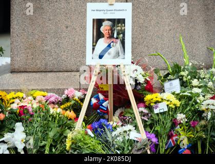 Manchester, Regno Unito, 10th settembre 2022. Una foto di sua Maestà, la Regina Elisabetta II, con i fiori lasciati in Piazza Sant'Anna, Manchester, Regno Unito, come omaggio a sua Maestà, la Regina. La Regina morì, all'età di 96 anni, il 8th settembre 2022. Il Manchester City Council ha dichiarato sul suo sito web che la città di Manchester osserverà il periodo ufficiale di lutto di 10 giorni e che: “I residenti potrebbero voler porre dei fiori per segnare la morte di sua Maestà. Potrete deporre fiori in Piazza Sant'Ann'. Credit: Terry Waller/Alamy Live News Foto Stock