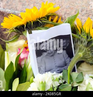 Manchester, Regno Unito, 10th settembre 2022. Una foto di sua Maestà, la Regina Elisabetta II, con i fiori lasciati in Piazza Sant'Anna, Manchester, Regno Unito, come omaggio a sua Maestà, la Regina. La Regina morì, all'età di 96 anni, il 8th settembre 2022. Il Manchester City Council ha dichiarato sul suo sito web che la città di Manchester osserverà il periodo ufficiale di lutto di 10 giorni e che: “I residenti potrebbero voler porre dei fiori per segnare la morte di sua Maestà. Potrete deporre fiori in Piazza Sant'Ann'. Credit: Terry Waller/Alamy Live News Foto Stock