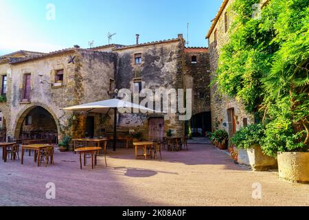 Piazza centrale del bellissimo borgo medievale di Monells con le sue case in pietra e viti verdi, Girona Catalonia. Foto Stock
