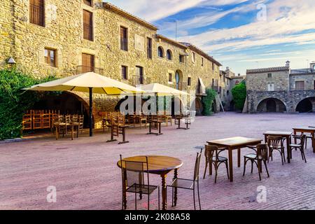 Piazza centrale del borgo medievale di Monells con le sue case in pietra e archi negli edifici, Girona, Spagna. Foto Stock