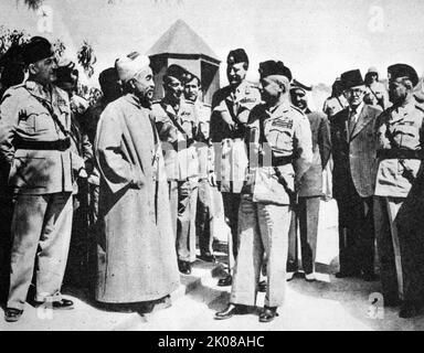 Re Abdullah di Transjordan (a sinistra) con il Brigadier Glubb Pasha e gli ufficiali dello staff. Abdullah i bin al-Husayn (2 febbraio 1882 11 – 20 1921 luglio 1951 1951) è stato un . Fu Emiro di Transjordan, un protettorato britannico, fino al 25 maggio 1946, dopo di che fu re di una Giordania indipendente. Tenente generale Sir John Bagot Glubb, KCB, CMG, DSO, OBE, MC, KStJ, KPM (16 aprile 1897 – 17 marzo 1986), noto come Glubb Pasha, è stato un soldato, studioso e autore britannico, che ha guidato e addestrato la Legione Araba di Transjordan tra il 1939 e il 1956 come suo comandante ge Foto Stock