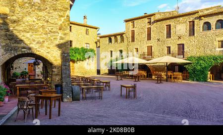 Piazza centrale del borgo medievale di Monells con le sue case in pietra e archi negli edifici, Girona, Spagna. Foto Stock