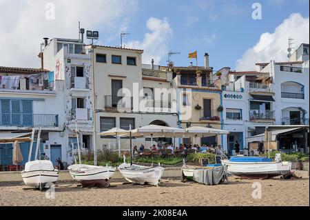 Blanes, Catalogna, Spagna - Agosto 04,2022: Case nella città costiera di Blanes della Costa Brava con barche da pesca di fronte e la bandiera di Cataloni Foto Stock