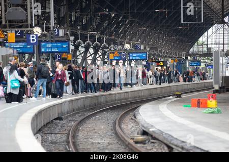 10 settembre 2022, Renania settentrionale-Vestfalia, Colonia: I passeggeri del treno aspettano sul binario per arrivare alla stazione centrale di Colonia. Il traffico ferroviario nella stazione centrale di Colonia è di nuovo in modo più o meno ordinato. Una scatola di segnale rotta aveva operazioni quasi completamente paralizzate. Foto: Thomas Banneyer/dpa Foto Stock