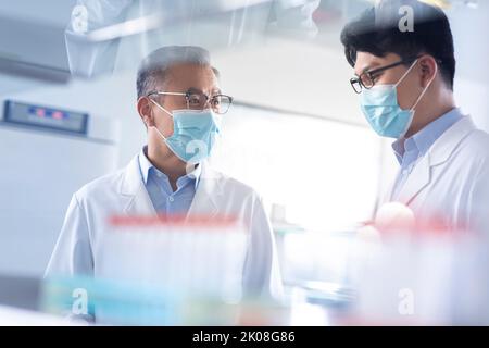 Ricercatori cinesi che discutono in laboratorio Foto Stock