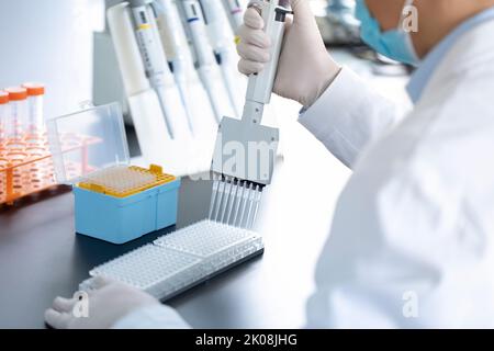 Campioni pipettati da scienziati cinesi in laboratorio Foto Stock