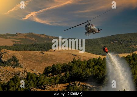 Elicottero contro gli incendi, effettuando uno scarico d'acqua. Foto Stock