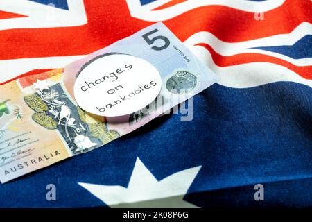 Cambio dell'immagine sulla banconota australiana in dollari, denaro giacente sulla bandiera australiana con l'iscrizione manuale: Cambio banconote, denaro ecc Foto Stock
