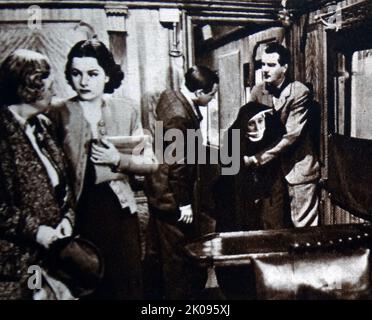 Maggio Whitty, Margaret Lockwood, Naunton Wayne, Catherine Lacey e Michael Redgrave nella Signora svanisce. The Lady Vanishes è un thriller di mistero britannico del 1938 diretto da Alfred Hitchcock. Dame Mary Louise Webster, DBE (Nee Whitty; 19 giugno 1865 – 29 maggio 1948), conosciuta professionalmente come May Whitty e più tardi, per il suo lavoro di beneficenza, Dame May Whitty, è stata un'attrice inglese. Margaret Lockwood (CBE, 15 settembre 1916 – 15 luglio 1990) è stata una . Naunton Wayne (nome Henry Wayne Davies, 22 giugno 1901 – 17 novembre 1970) è stato un Foto Stock