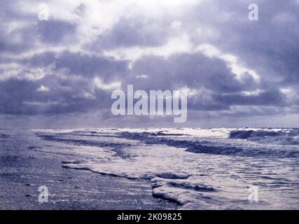 Su Una spiaggia di scaffalatura. Fotografia in bianco e nero della riva del lago Tegernsee, una città del distretto di Miesbach in Baviera, Germania. Una città termale, è circondata da un paesaggio alpino dell'alta Baviera, e ha un'economia principalmente basata sul turismo. Foto Stock