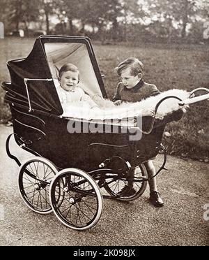 Il Principe Carlo, nel suo Pram, con il Principe Richard di Gloucester, a Green Park, Londra. Carlo, Principe di Galles (Charles Philip Arthur George, 14 novembre 1948), è l'erede apparso al trono britannico come figlio maggiore della regina Elisabetta II È stato erede apparente così come Duca di Cornovaglia e Duca di Rothesay dal 1952. Alla morte di suo padre, il principe Filippo, il 9 aprile 2021, Carlo ereditò anche il titolo di Duca di Edimburgo. Principe Richard, Duca di Gloucester, KG, GCVO, GCStJ, FRIBA (Richard Alexander Walter George, 26 agosto 1944) è un Foto Stock