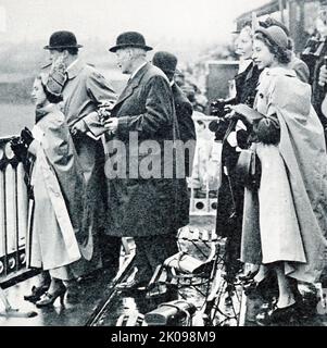 La principessa Elizabeth (a sinistra) e la principessa Margaret, nel box di Lord Sefton, guardando Monaveen, posseduta in collaborazione dalla principessa Elizabeth e la regina, corrono nel 1950 Grand National ad Aintree. Principessa Margaret, Contessa di Snowdon, ci, GCVO, CD (Margaret Rose; 21 agosto 1930 - 9 febbraio 2002) fu la figlia minore di re Giorgio VI e della regina Elisabetta e l'unico fratello della regina Elisabetta II Principessa Elisabetta. Elizabeth II (Elizabeth Alexandra Mary, 21 aprile 1926) è una regina del Regno Unito e 15 altri regni del Commonwealth. È la figlia maggiore di re Giorgio VI e Regina Foto Stock