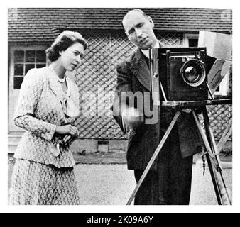 La principessa Elisabetta ispezionando una macchina fotografica al Windlesham Camera Club. Principessa Elisabetta. Elizabeth II (Elizabeth Alexandra Mary, 21 aprile 1926) è una regina del Regno Unito e 15 altri regni del Commonwealth. È la figlia maggiore del re Giorgio VI e della regina Elisabetta. Foto Stock