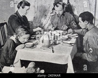 Nazi Storm Trooper Johann Laub mangiare a casa con la sua famiglia. Lo Sturmabteilung era l'ala paramilitare originale del partito nazista. Ha giocato un ruolo significativo nell'ascesa al potere di Adolf Hitler negli anni '1920s e '1930s. Foto Stock