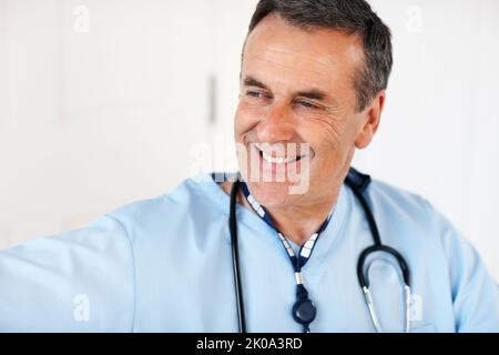 Un medico esperto e maturo sorridente contro il bianco. Primo piano ritratto di medico esperto, maturo sorridente contro il bianco. Foto Stock