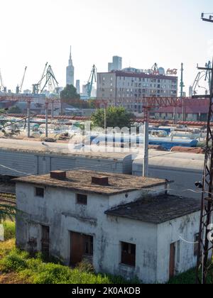 Batumi, Georgia. 08.30.2022 Ferrovia in città. Scarti abbandonati. Gru portuali ed edifici alti. Molti percorsi ferroviari. Vagoni e treni sulla t Foto Stock