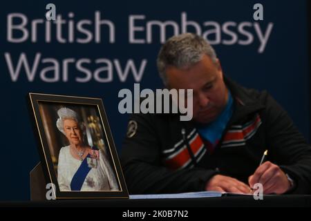 VARSAVIA, POLONIA. 10 settembre 2022. Un uomo firma un libro di condoglianze presso l'Ambasciata del Regno Unito a Varsavia, Polonia. La regina Elisabetta II morì al castello di Balmoral in Scozia il 8 settembre 2022, ed è succeduta dal suo figlio maggiore, re Carlo III Credit: ASWphoto/Alamy Live News Foto Stock